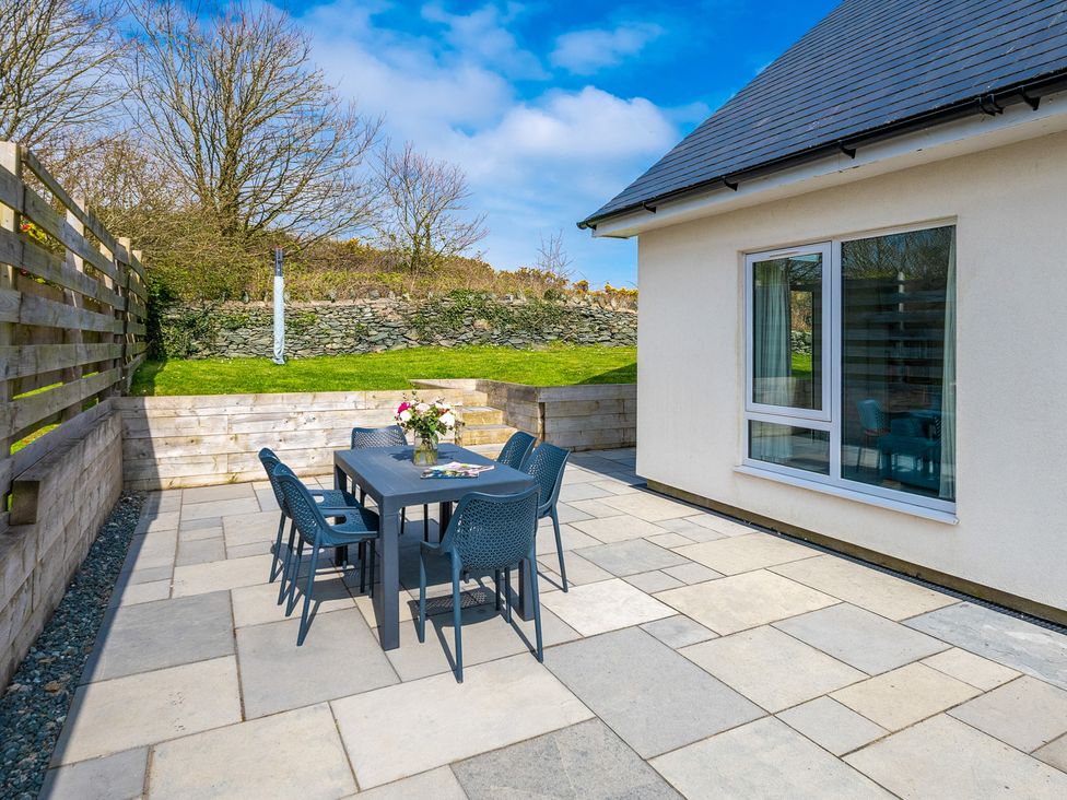 An outdoor patio with a table and chairs at Moranedd Bach Holyhead
