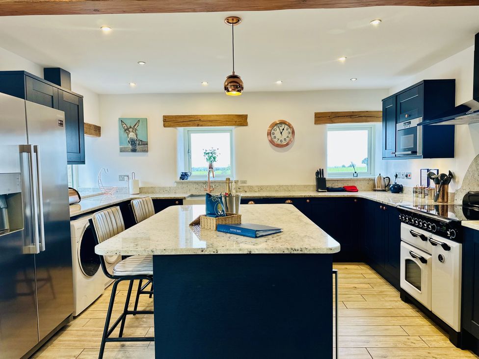 A kitchen with a central island and appliances at Pastures Barn in Bradnop near Leek