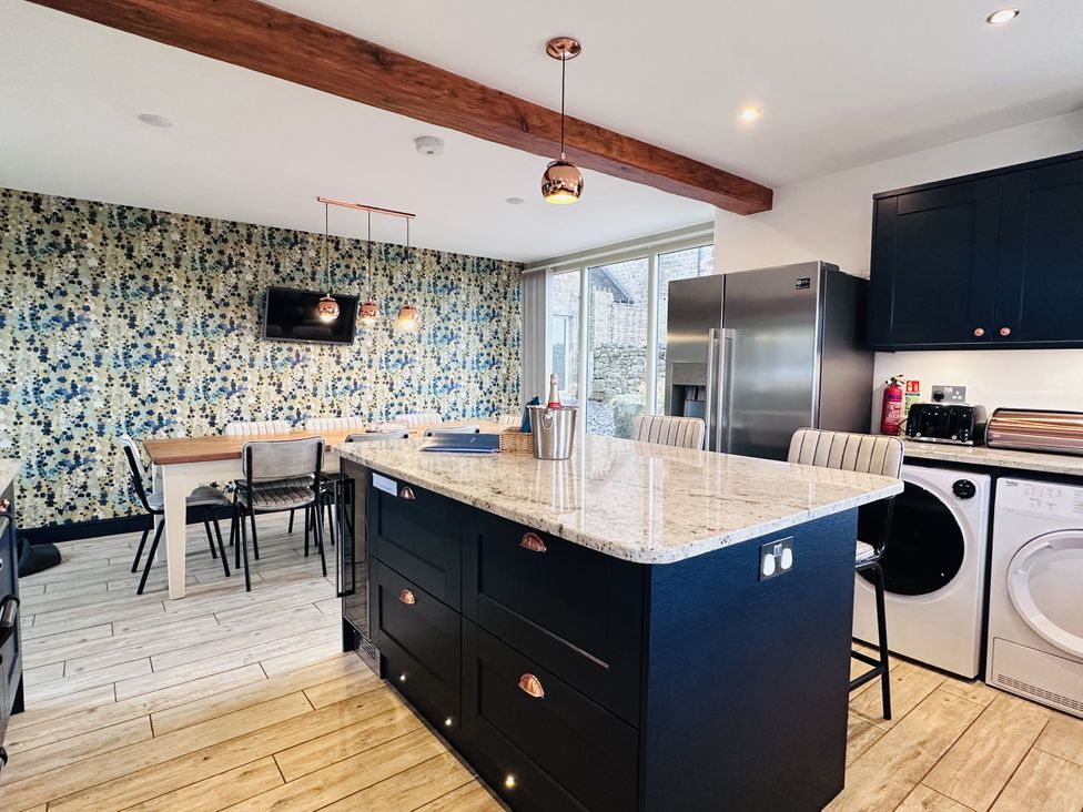 A kitchen with an island and dining table at Pastures Barn in Bradnop near Leek