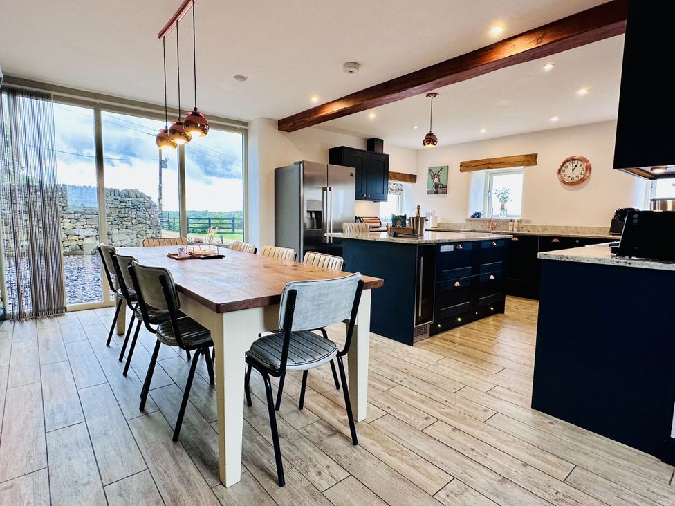 A kitchen with a dining table and chairs at Pastures Barn in Bradnop near Leek
