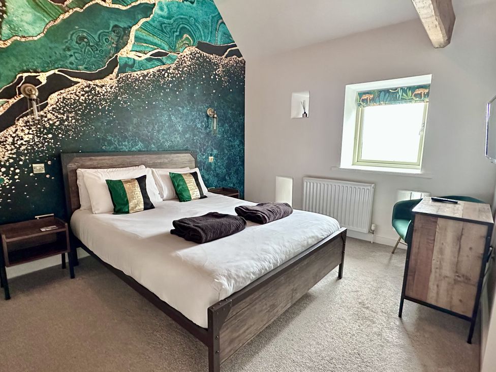 A bedroom with a bed and desk at Pastures Barn in Bradnop near Leek