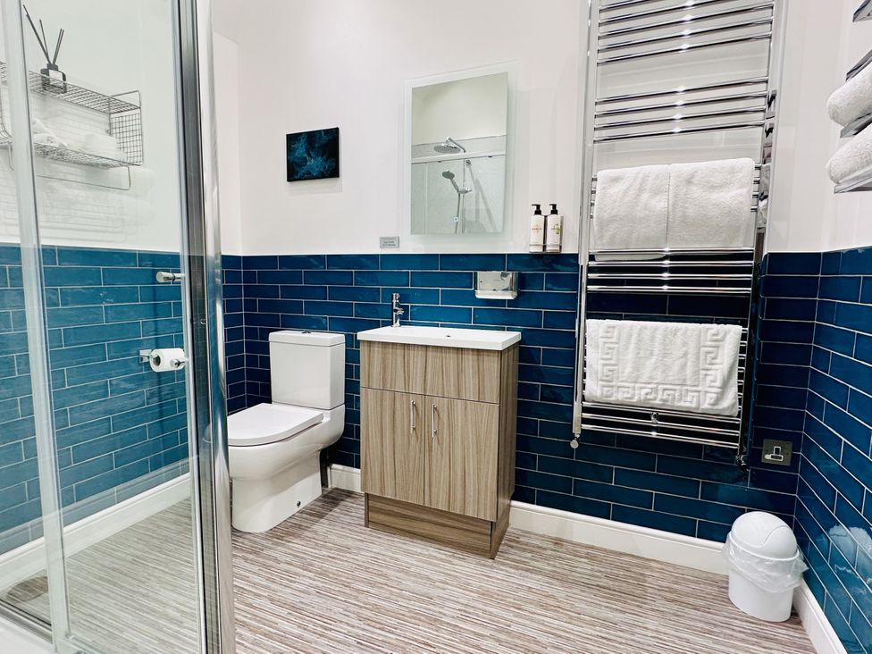 A bathroom with a toilet, wash basin, and shower at Pastures Barn, Bradnop near Leek