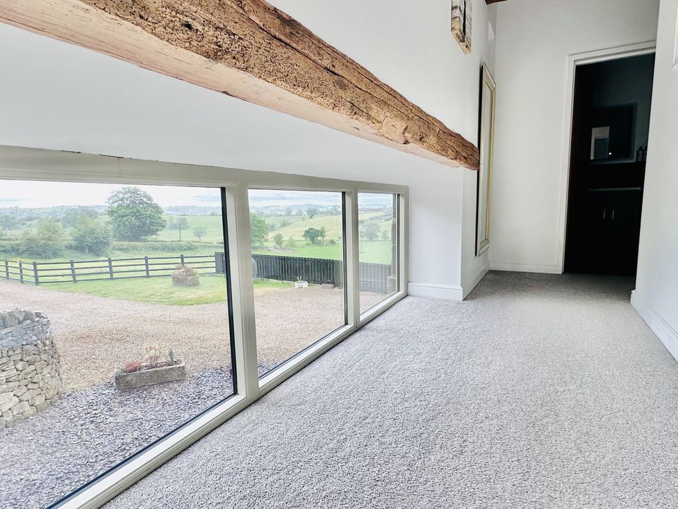 A hallway with a large window and door at Pastures Barn in Bradnop near Leek