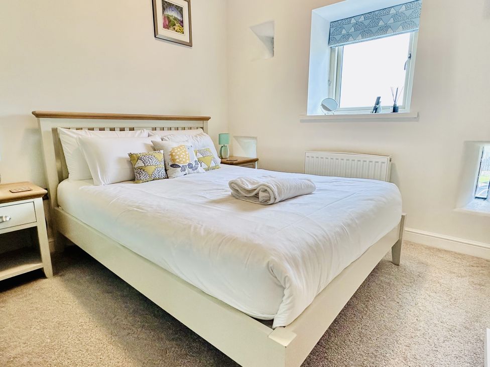 A bedroom with a bed and bedside table at Pastures Barn Bradnop near Leek
