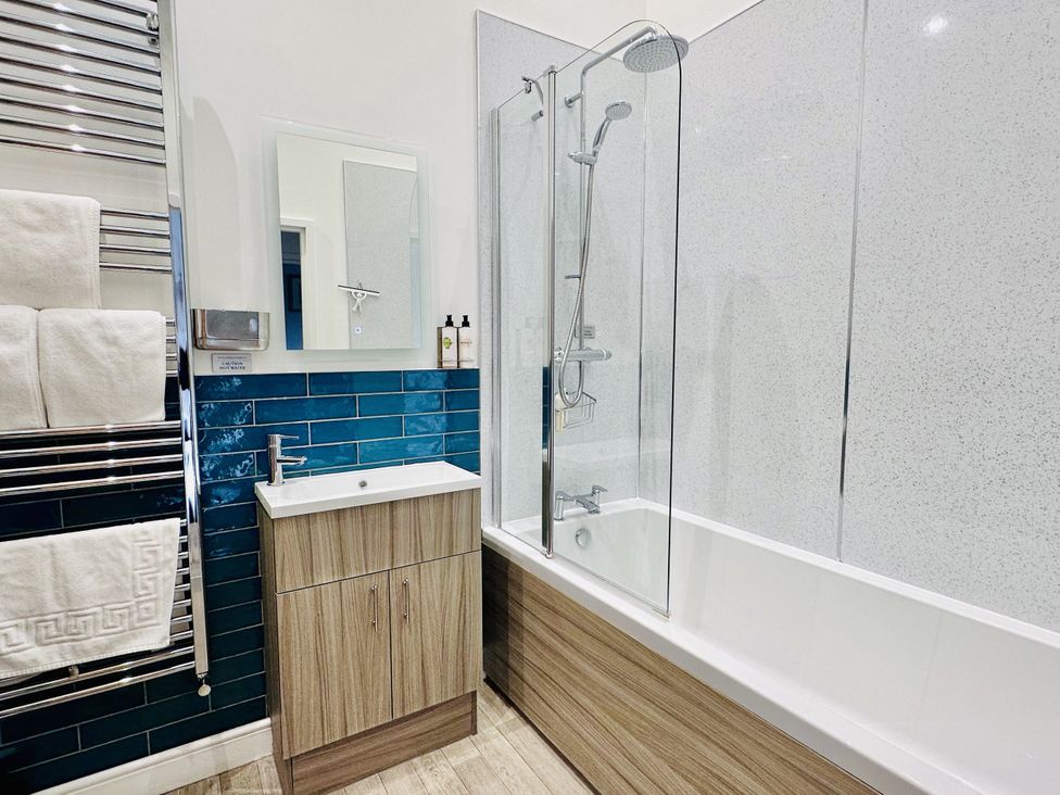 A bathroom with a bathtub and shower unit at Pastures Barn in Bradnop near Leek