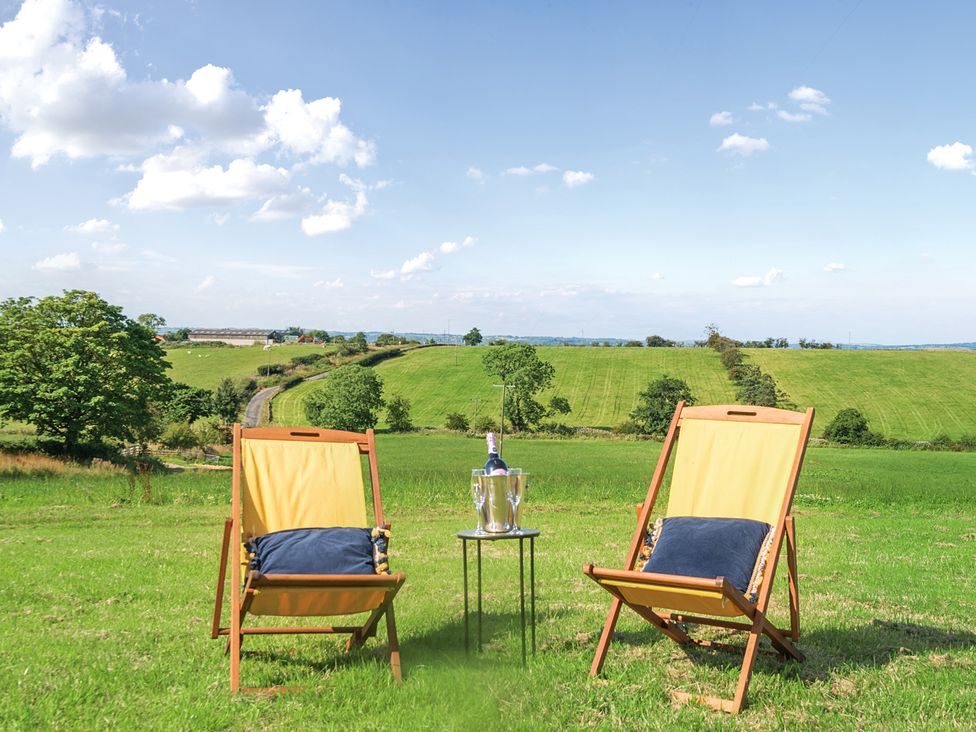 Two deck chairs and a table with champagne in a field at Pastures Barn Bradnop near Leek