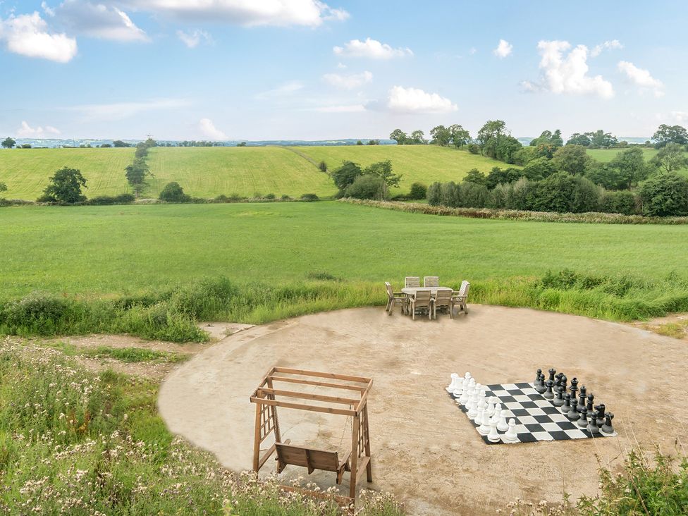 An outdoor area with a large chess set and table with chairs at Pastures Barn Bradnop near Leek
