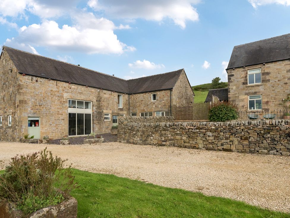 An exterior view of stone buildings with a gravel driveway at Pastures Barn Bradnop near Leek