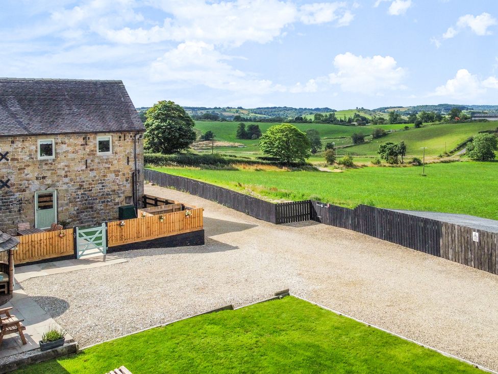 An outdoor area with a stone building and fence at Pastures Barn Bradnop near Leek