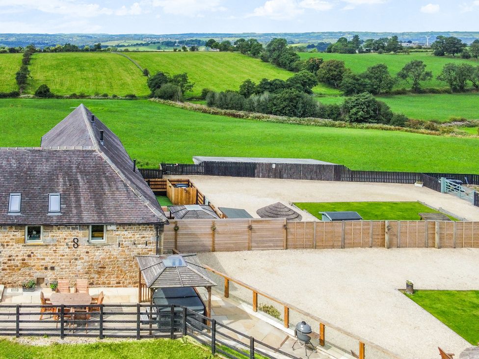 An outdoor area with a table and chairs near a barn at Pastures Barn Bradnop near Leek