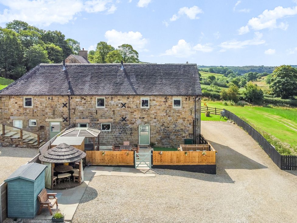An outdoor area with seating and a barn at Pastures Barn in Bradnop near Leek