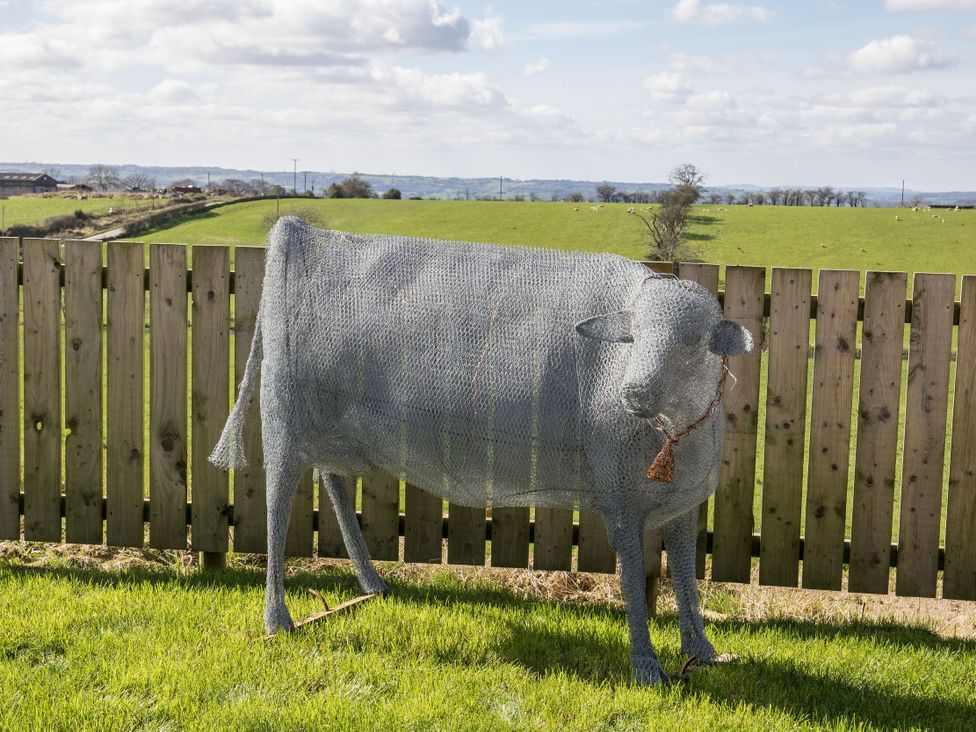 A wire sculpture of a cow in a field at Pastures Barn Bradnop near Leek
