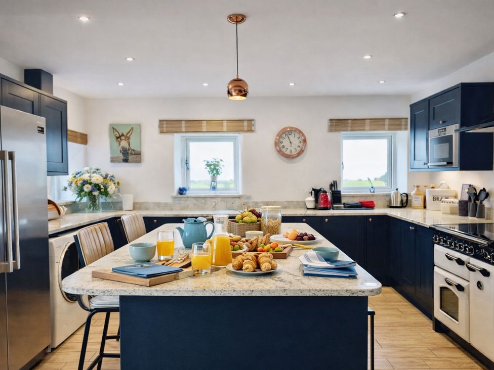 A kitchen with a central island and breakfast items at Pastures Barn Bradnop near Leek