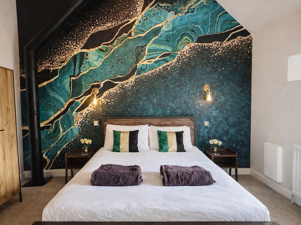 A bedroom with a bed and wall art at Pastures Barn Bradnop near Leek