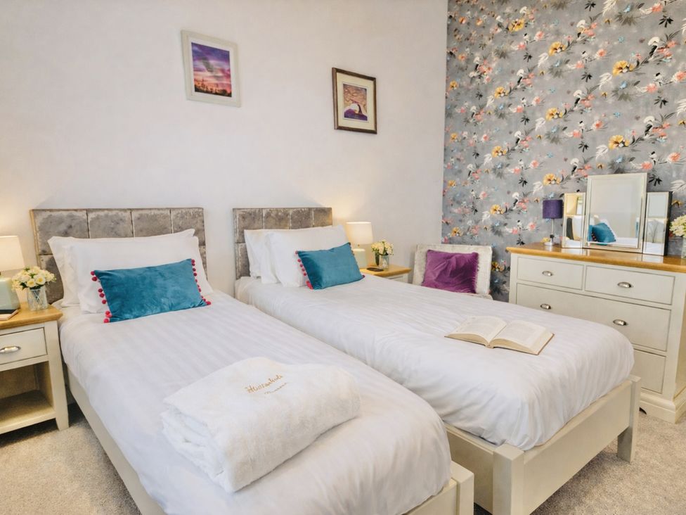 A bedroom with twin beds and a dresser at Pastures Barn in Bradnop near Leek