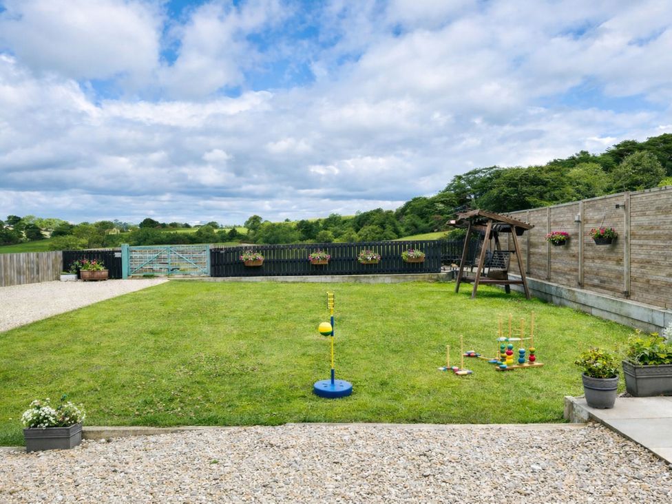 A garden with a swing set and toys at Pastures Barn Bradnop near Leek