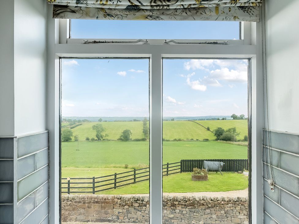 A view of fields and a fence through a window at HollyDale in Bradnop near Leek