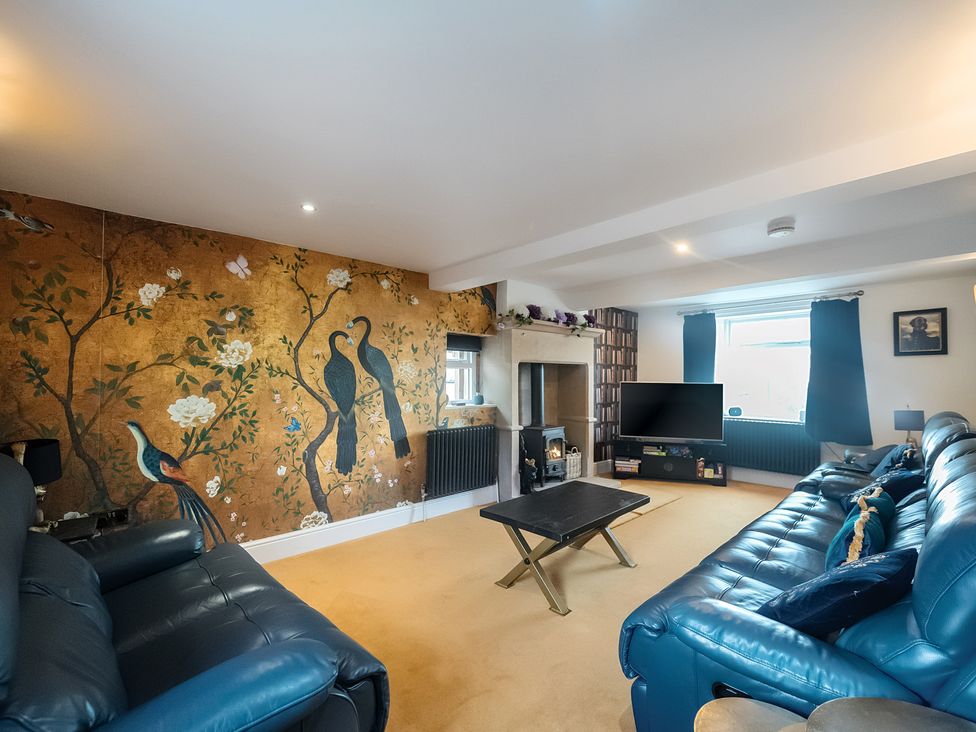 A living room with a mural and two sofas at HollyDale in Bradnop near Leek