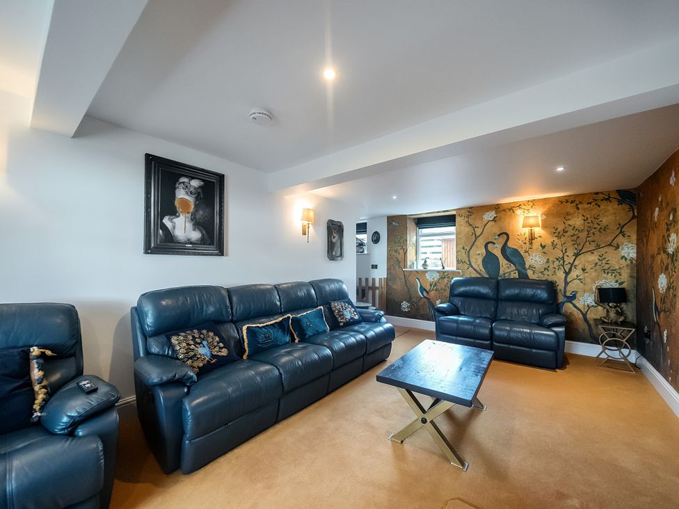 A living room with blue sofas and a coffee table at HollyDale in Bradnop near Leek