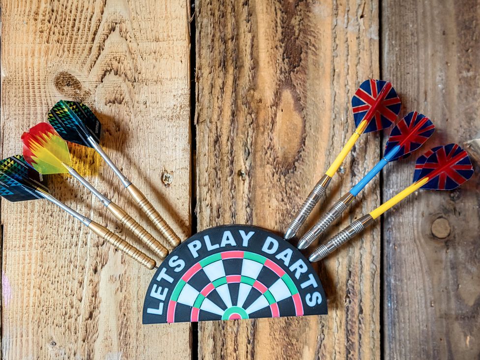 Darts and a dartboard sign on a wooden surface at HollyDale in Bradnop near Leek