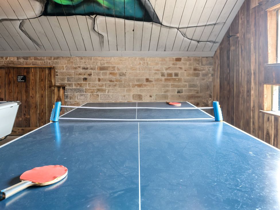 A ping pong table with a paddle in a recreation room at HollyDale in Bradnop near Leek