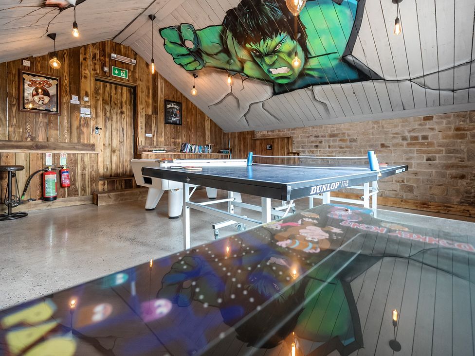 A game room with a table tennis table and wooden walls at HollyDale in Bradnop near Leek