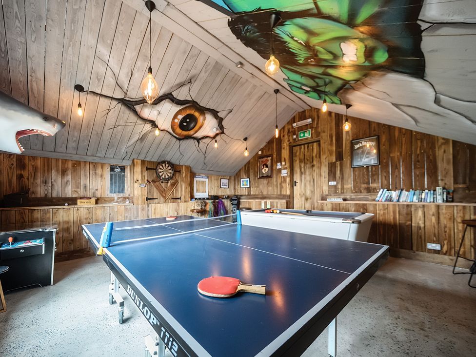 A game room with a ping pong table and darts board at HollyDale in Bradnop near Leek