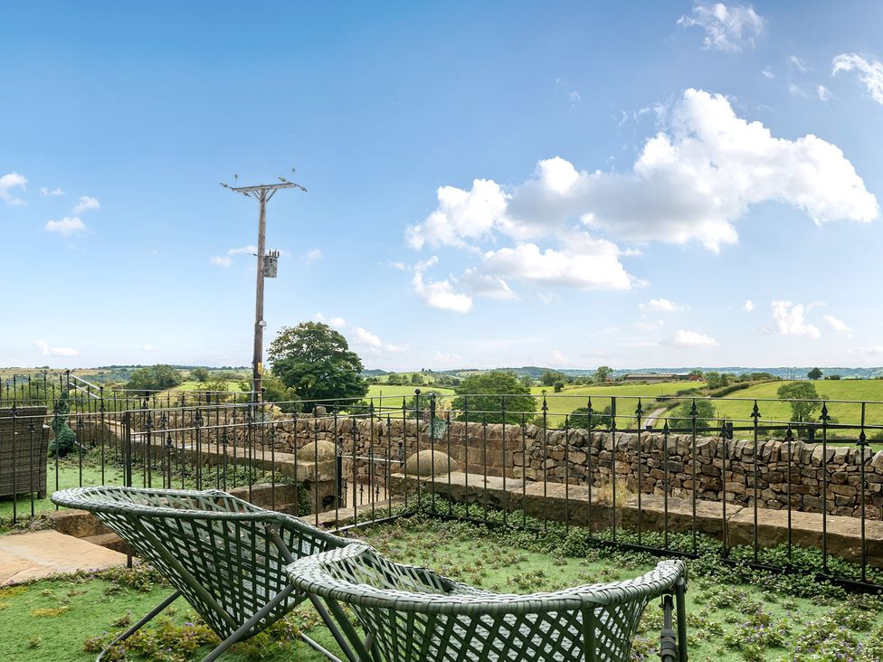 An outdoor space with green chairs and a view of the field at HollyDale in Bradnop near Leek