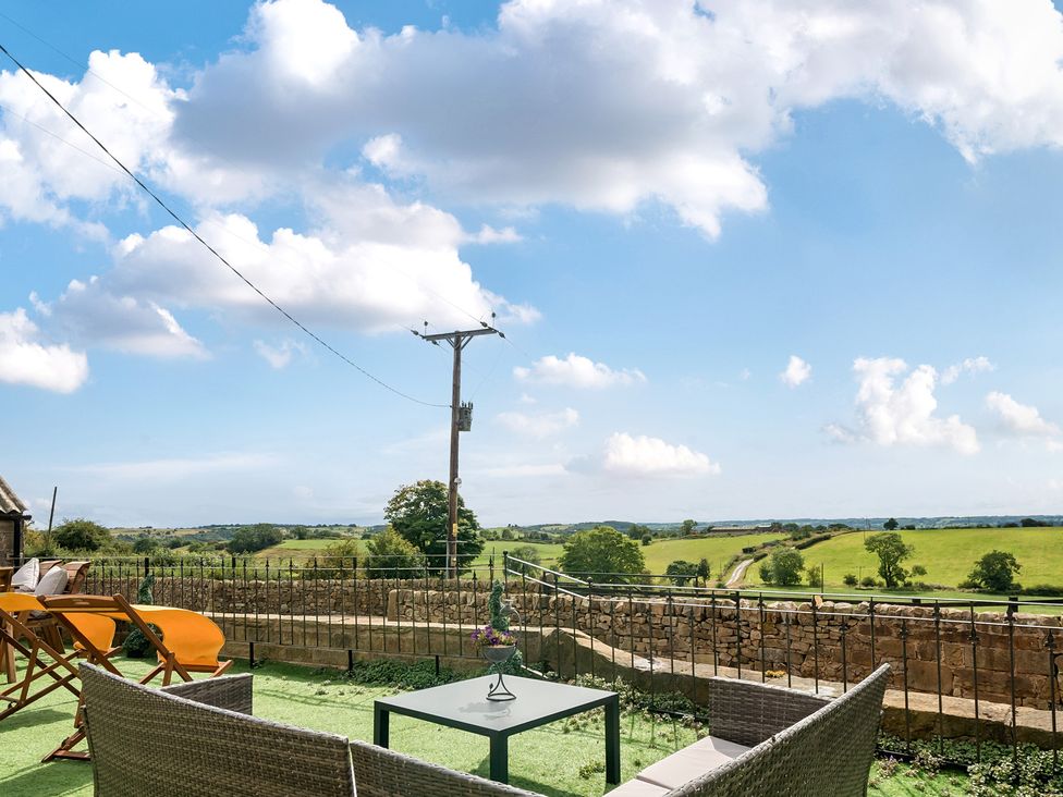 An outdoor seating area with chairs and a table overlooking fields at HollyDale in Bradnop near Leek