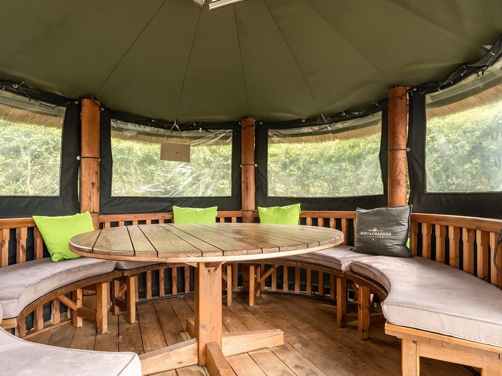 A garden gazebo with a round table and benches at HollyDale in Bradnop near Leek