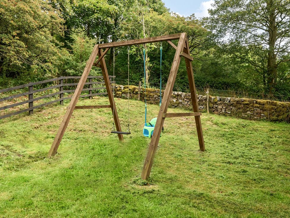 A garden with a wooden swing set at HollyDale in Bradnop near Leek