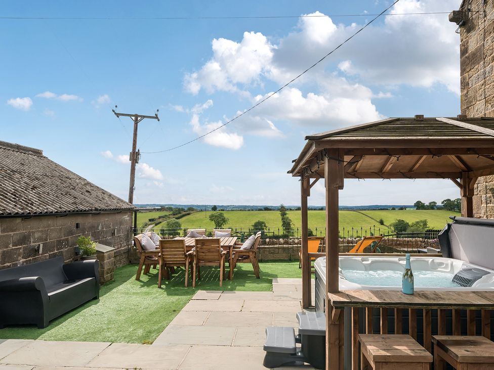 An outdoor seating area with a table and hot tub at HollyDale in Bradnop near Leek