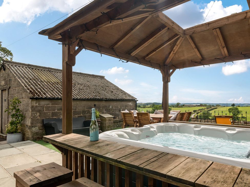 An outdoor area with a hot tub and seating at HollyDale in Bradnop near Leek