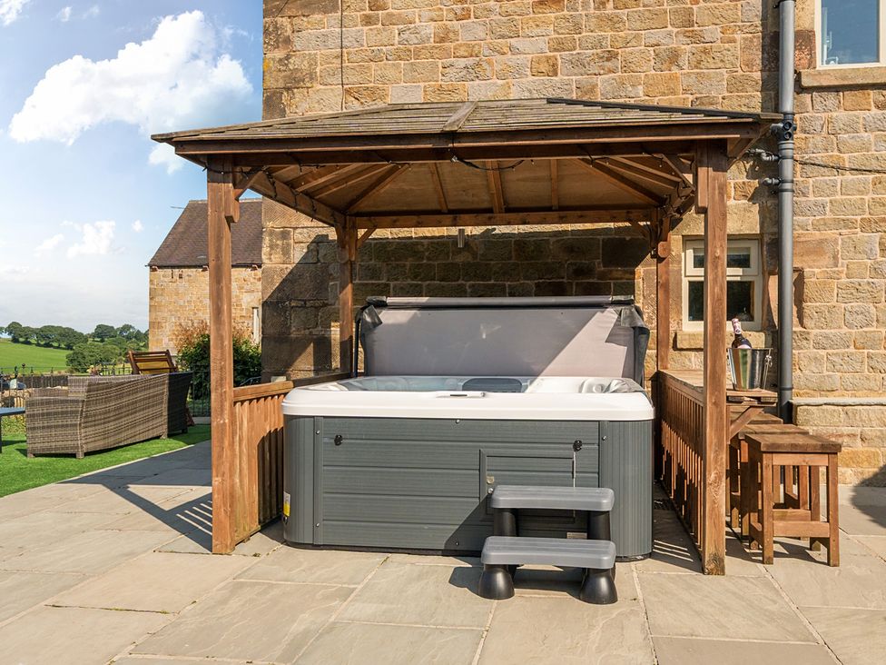 An outdoor area with a hot tub under a wooden shelter at HollyDale in Bradnop near Leek