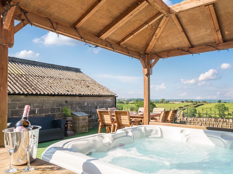 An outdoor area with a hot tub and seating at HollyDale in Bradnop near Leek