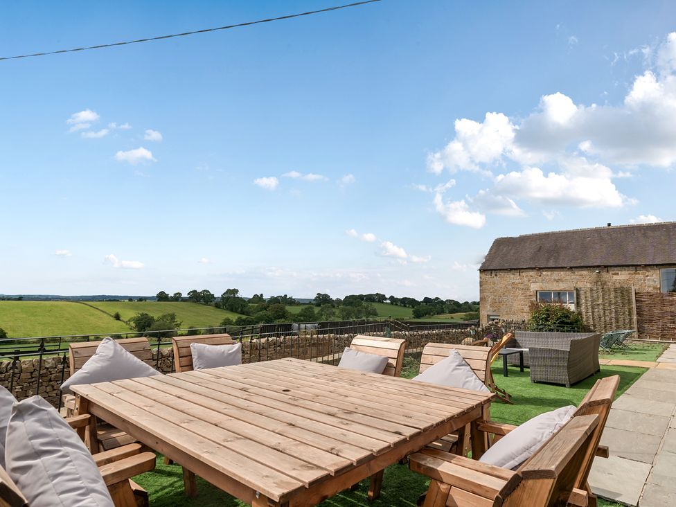 An outdoor area with a wooden table and chairs at HollyDale in Bradnop near Leek