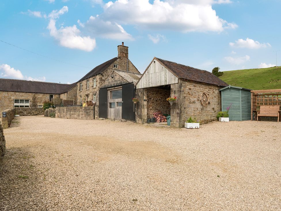 An outdoor area with a house, garage, and bench at HollyDale in Bradnop near Leek