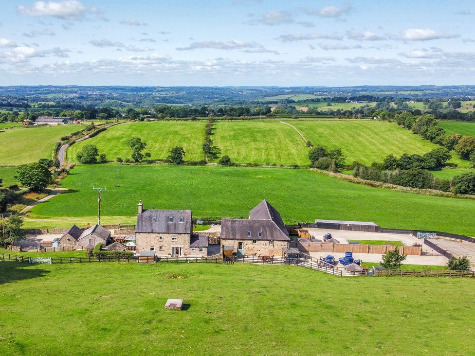 A farmhouse surrounded by fields and trees at HollyDale in Bradnop near Leek