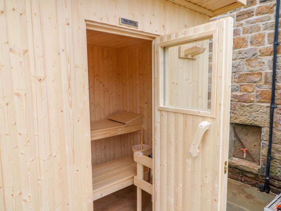 A sauna with wooden benches and an open door at HollyDale in Bradnop near Leek