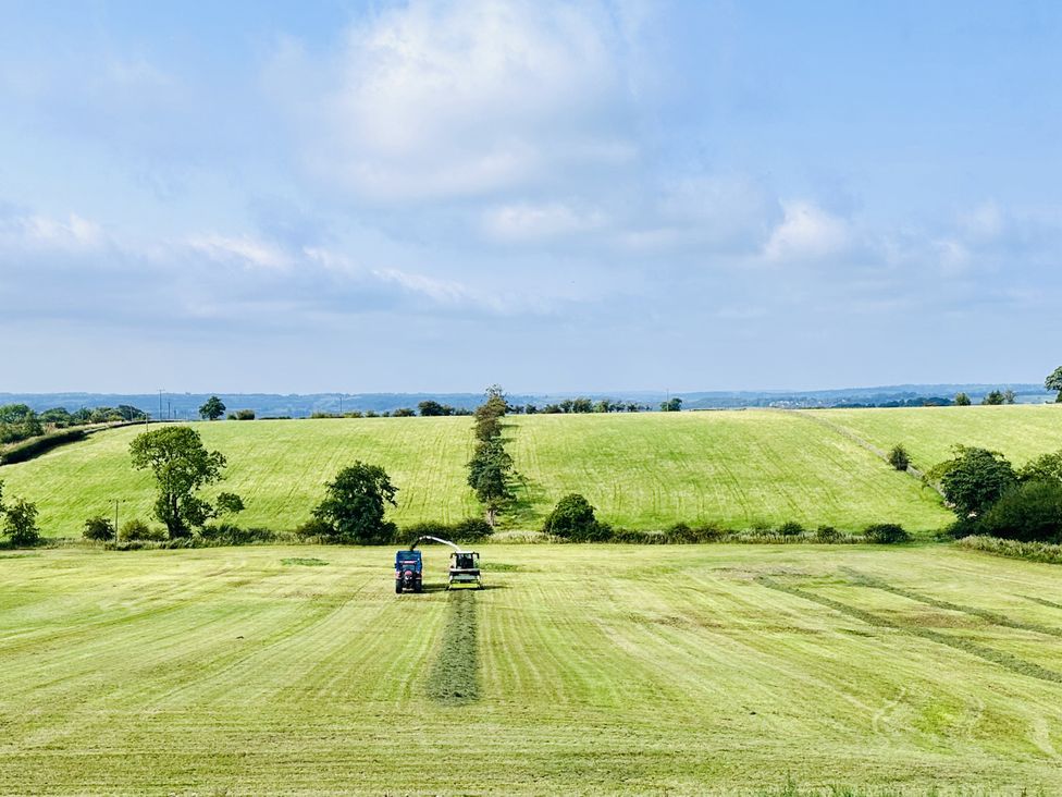 A field with two tractors working at HollyDale in Bradnop near Leek
