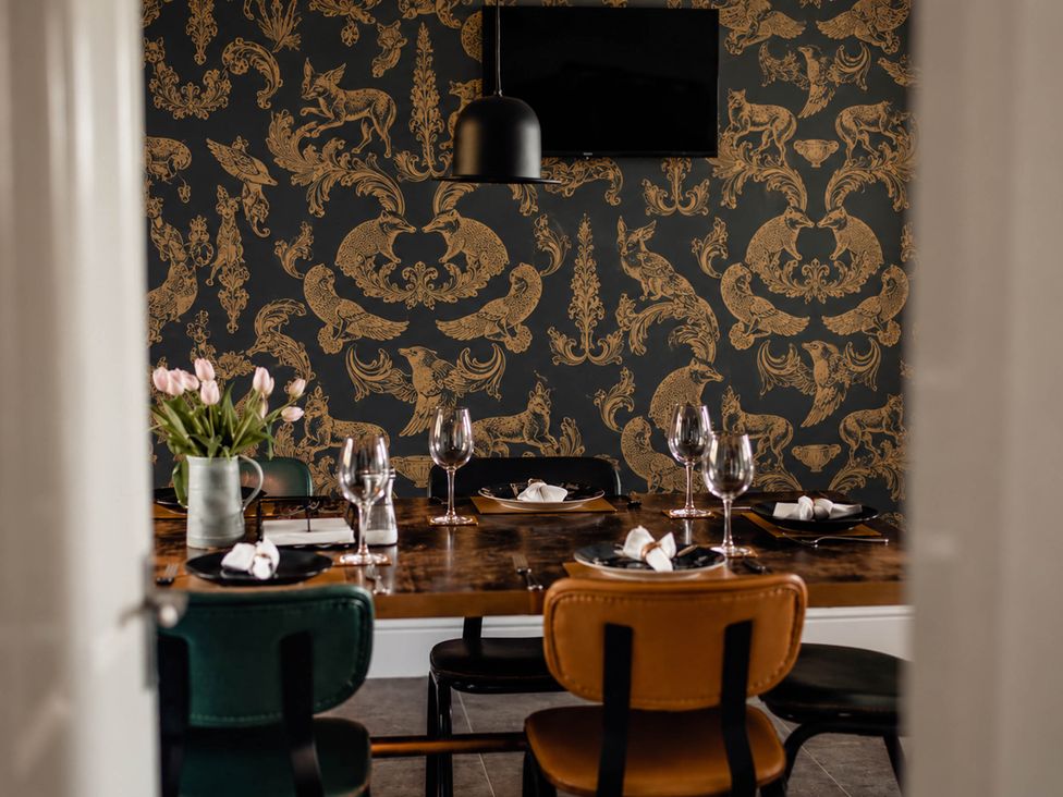 A dining room with a table set and a floral arrangement at HollyDale in Bradnop near Leek