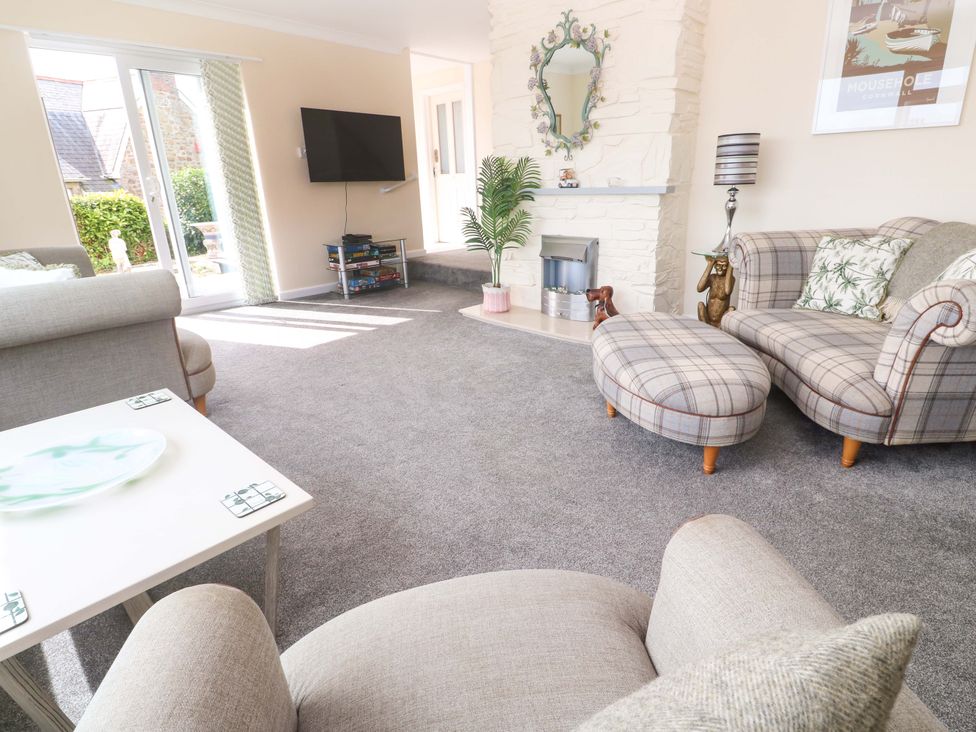 A living room with a TV and seating at Karenza in Penzance
