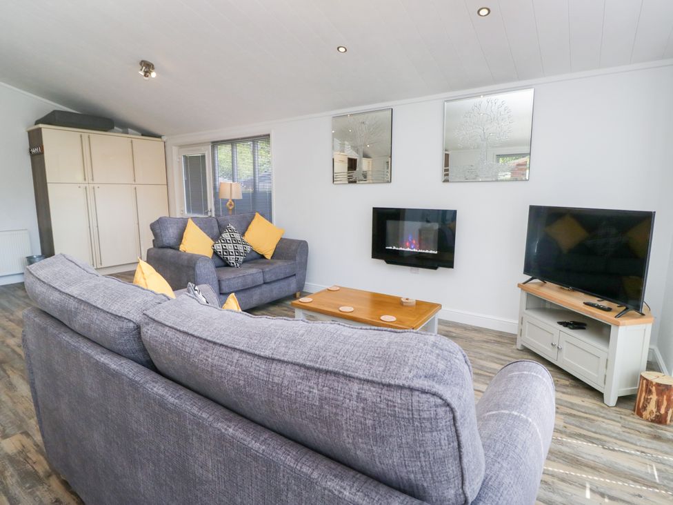 A living room with a sofa and television at Dovedale Lodge Troutbeck Bridge