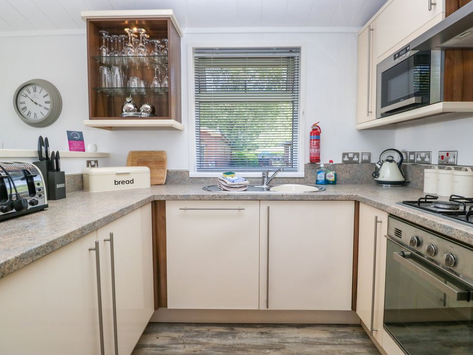 A kitchen with appliances and a window at Dovedale Lodge Troutbeck Bridge