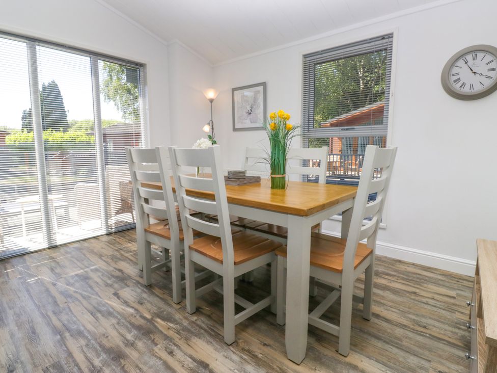A dining room with a table and chairs at Dovedale Lodge Troutbeck Bridge