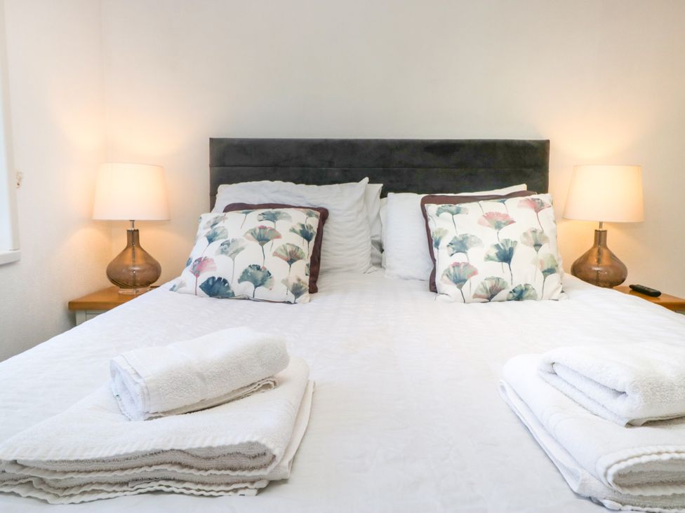 A bedroom with a bed and bedside lamp at Dovedale Lodge Troutbeck Bridge