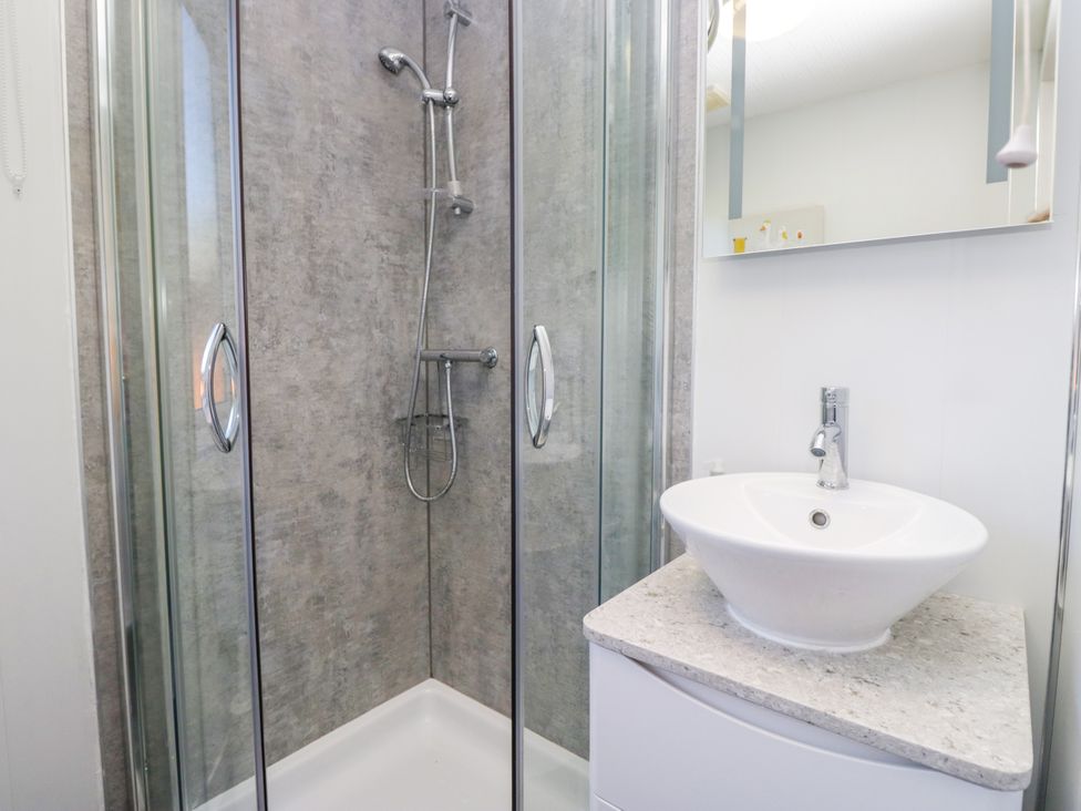 A bathroom with a shower and a sink at Dovedale Lodge Troutbeck Bridge