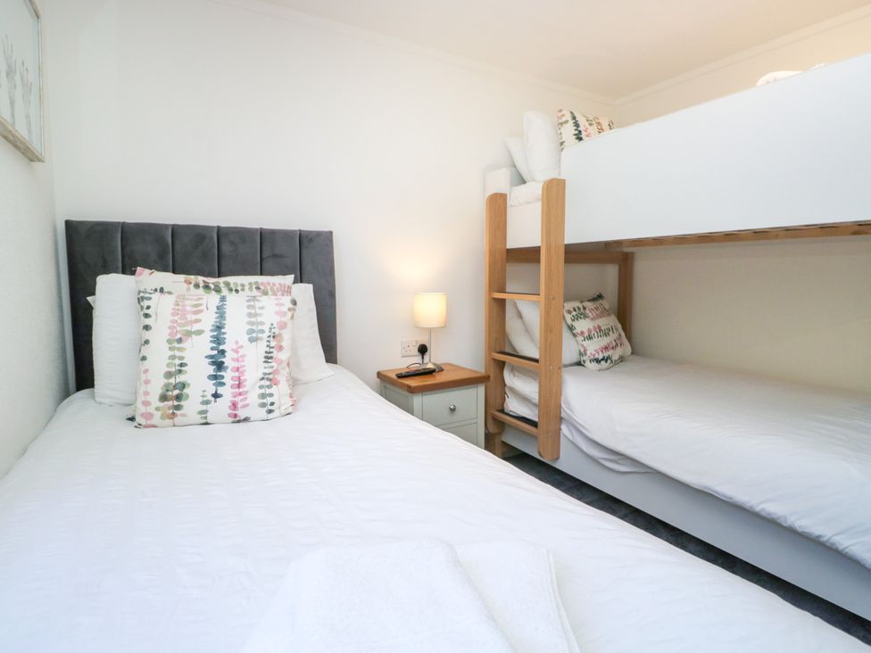 A bedroom with a bed and a bunk bed at Dovedale Lodge Troutbeck Bridge
