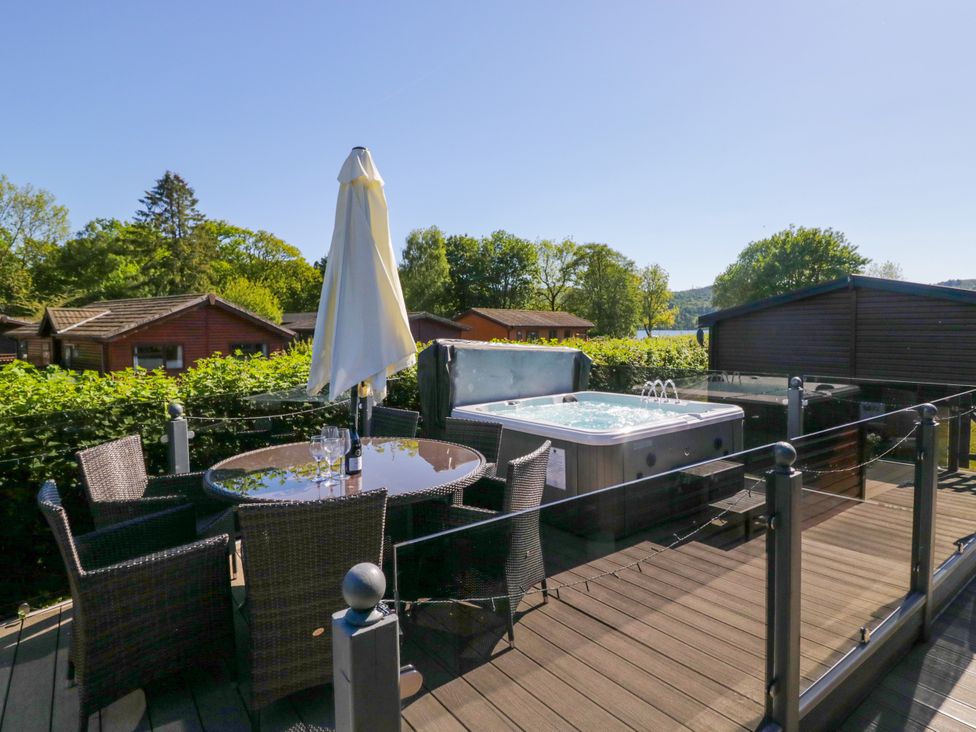An outdoor area with a hot tub and seating at Dovedale Lodge Troutbeck Bridge