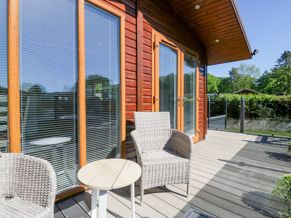 An outdoor seating area with chairs and a table at Dovedale Lodge Troutbeck Bridge
